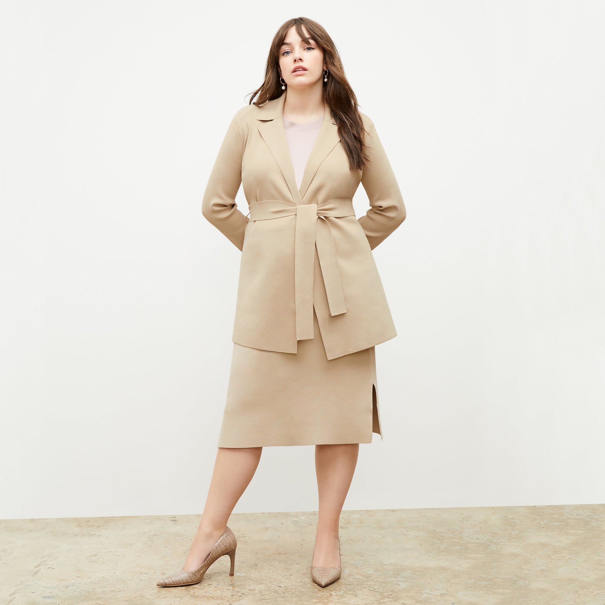 Front image of a woman standing wearing the Merritt jardigan in latte | Exclude