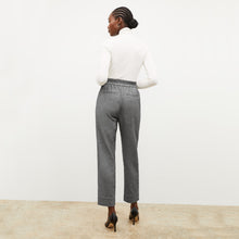 Back image of a woman standing wearing the axam top in ivory