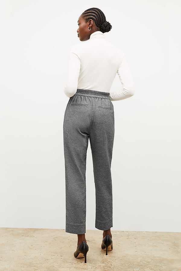 Back image of a woman standing wearing the axam top in ivory | Exclude