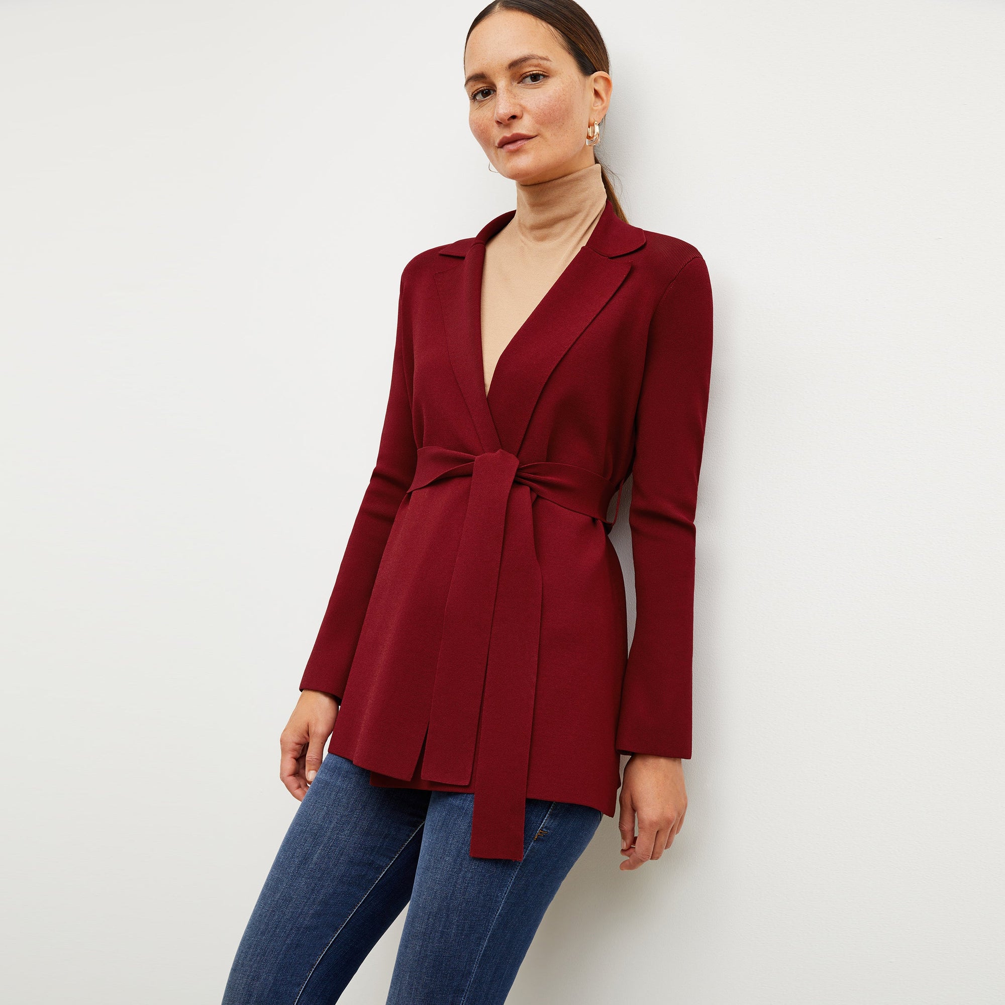 Front image of a woman standing wearing the axam top in camel | Exclude