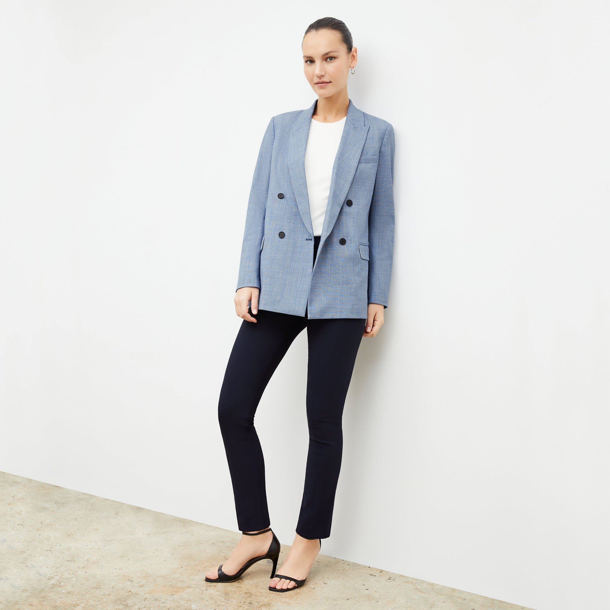 Front image of a woman standing wearing the foster pant in dark navy