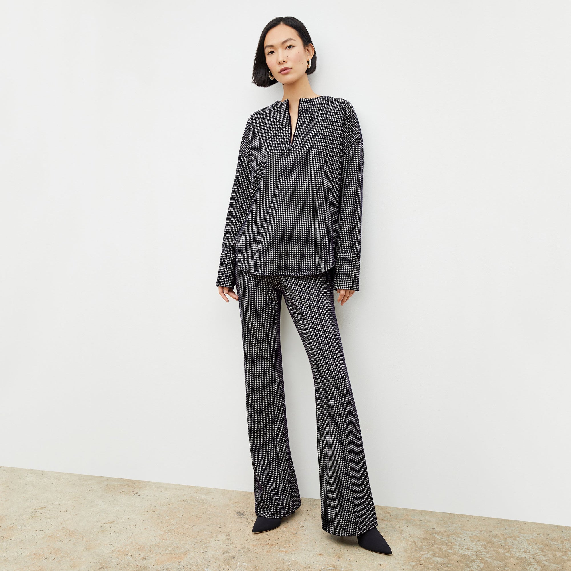 Front image of a woman wearing the horton pant in black and white houndstooth