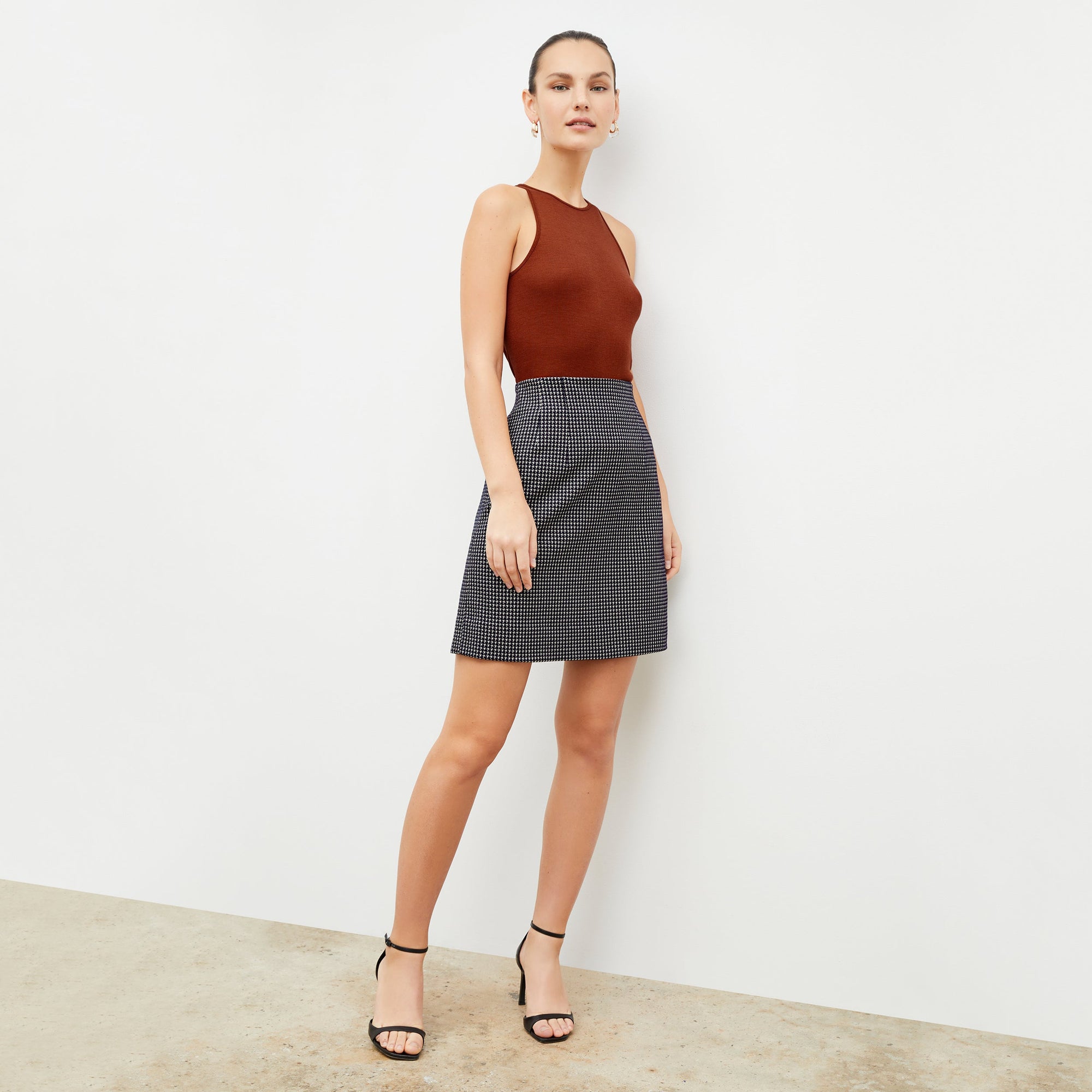 Front image of a woman wearing the whitney skirt in black and white