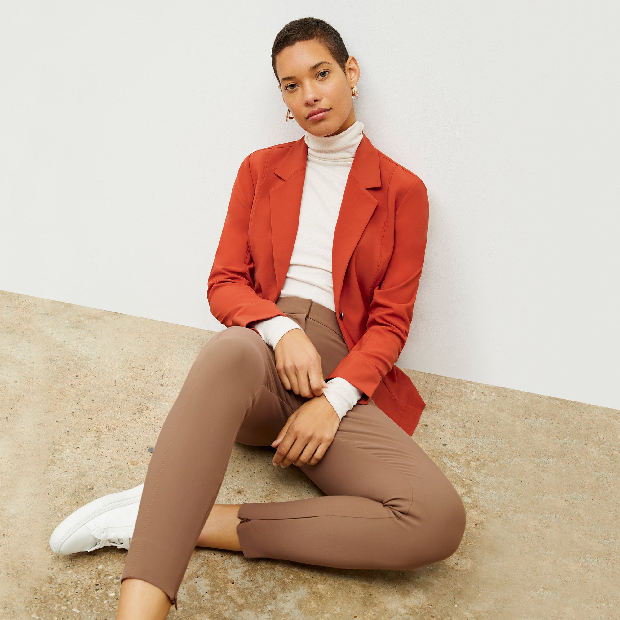 Front image of a woman standing wearing the axam top in ivory | Exclude