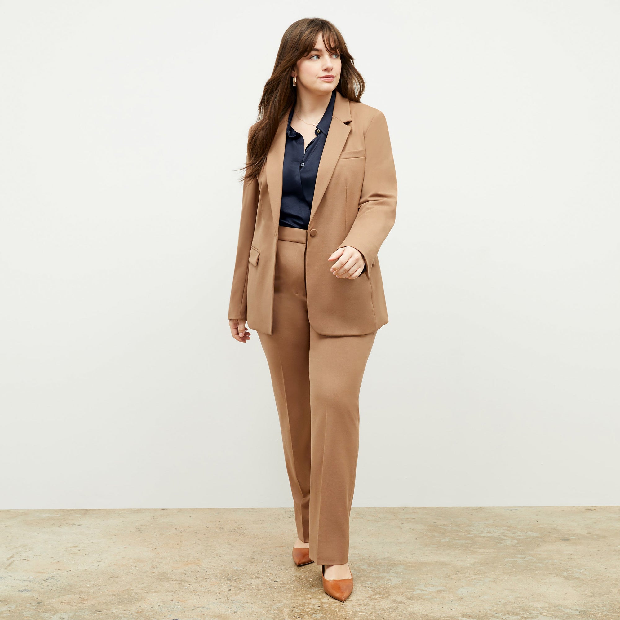 Front image of a woman standing wearing the Yiyan Blazer in Camel | Exclude
