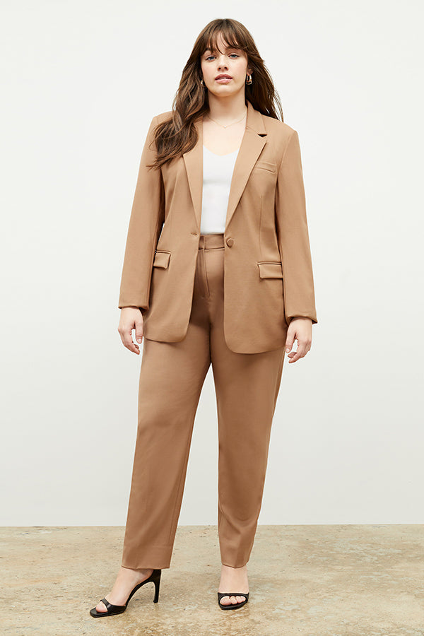 Front image of a woman standing wearing the Yiyan Blazer in Camel | Exclude