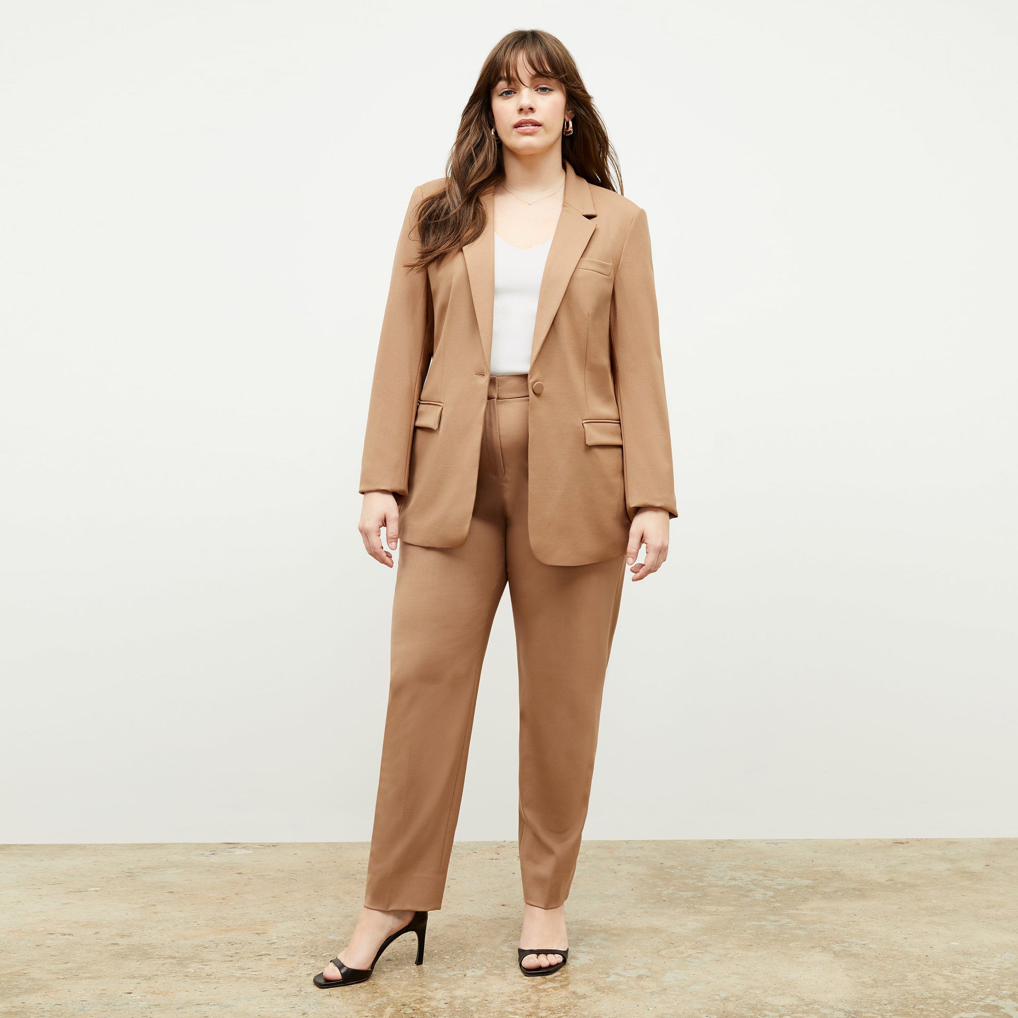 Front image of a woman standing wearing the Yiyan Blazer in Camel | Exclude