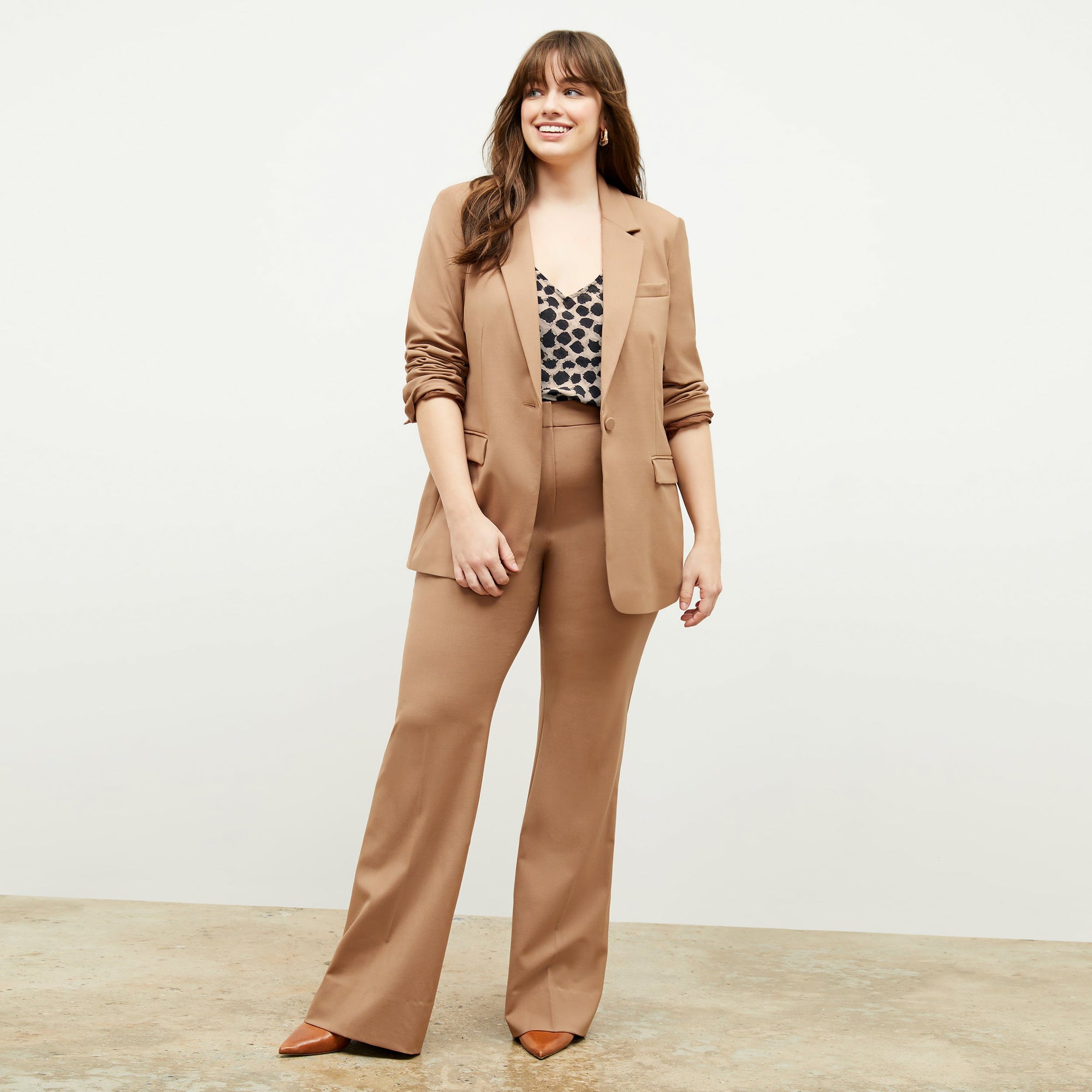 Front image of a woman standing wearing the Yiyan Blazer in Camel | Exclude