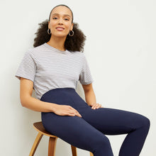 Front image of a woman standing wearing the foster pant in dark navy