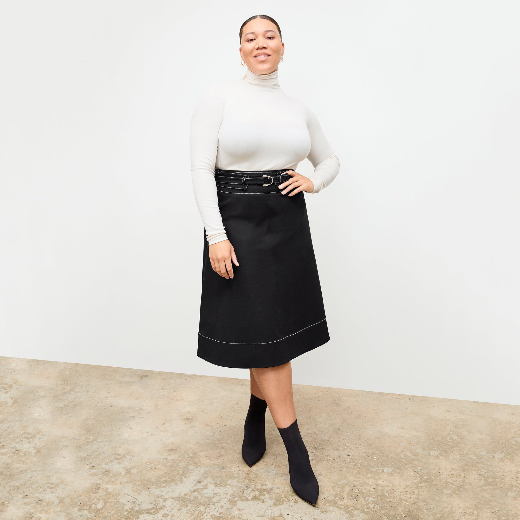 Front image of a woman standing wearing the axam top in ivory | Exclude
