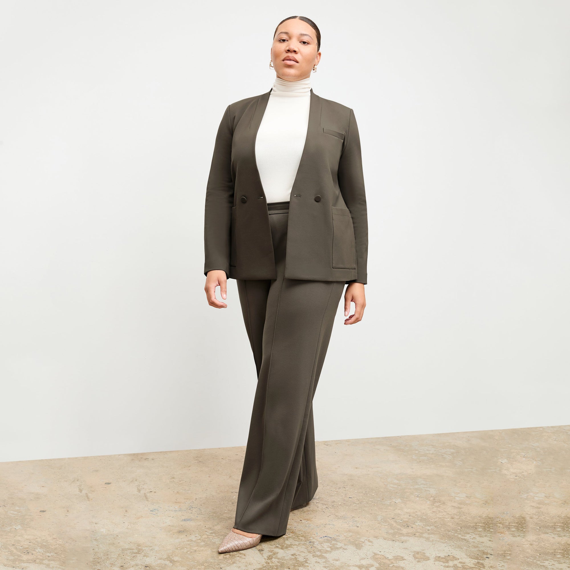 Front image of a woman standing wearing the axam top in ivory | Exclude