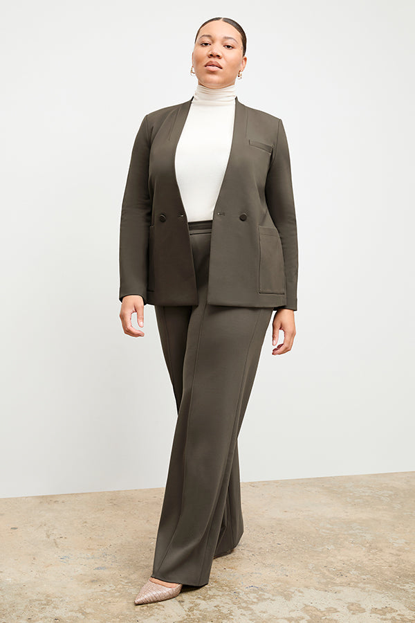 Front image of a woman standing wearing the axam top in ivory | Exclude