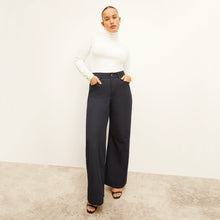 Front image of a woman standing wearing the axam top in ivory