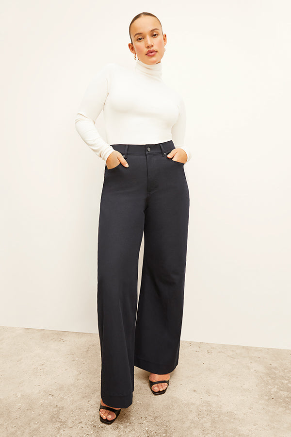 Front image of a woman standing wearing the axam top in ivory | Exclude