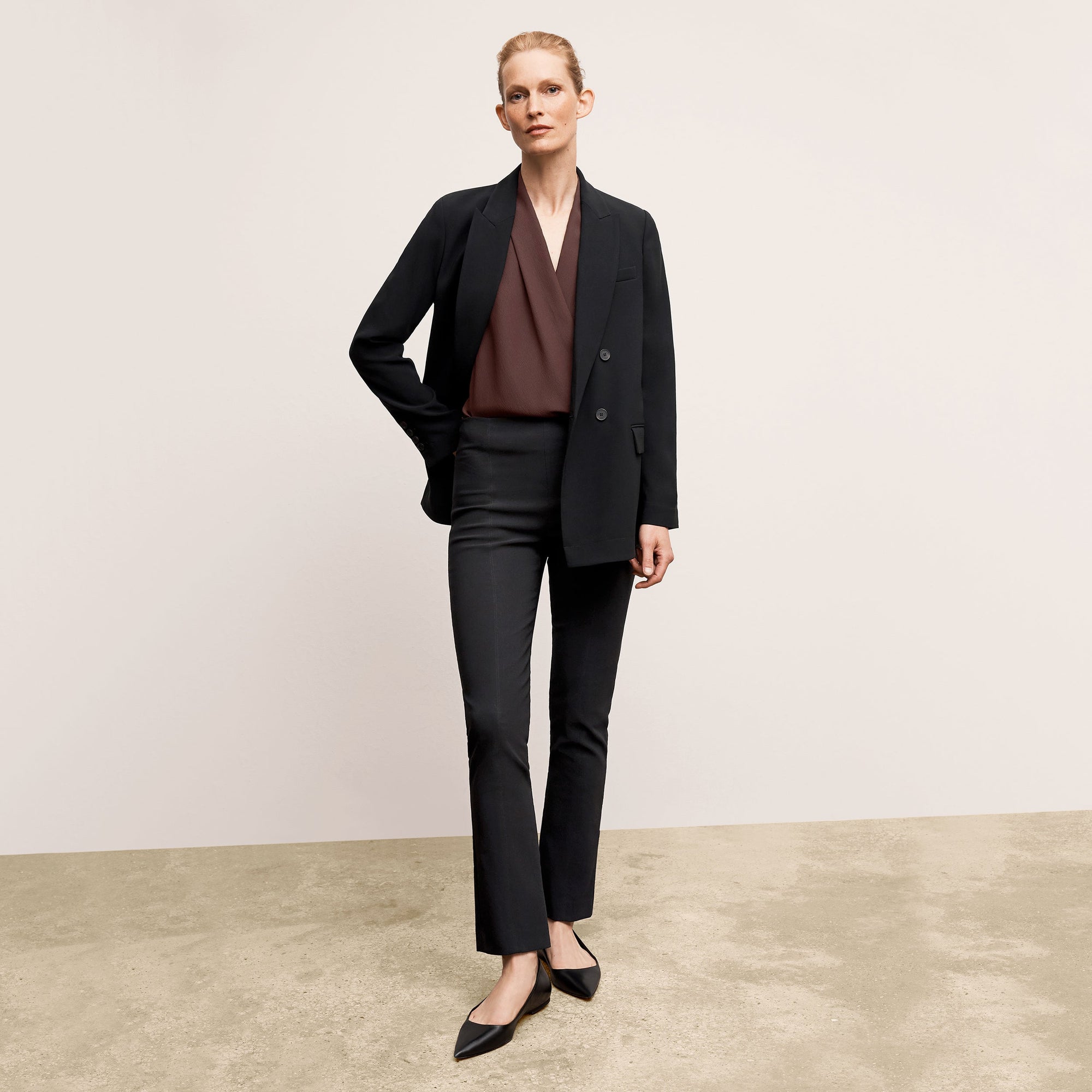 Front image of a woman standing wearing the Foster Pant—Everstretch in Black | Exclude