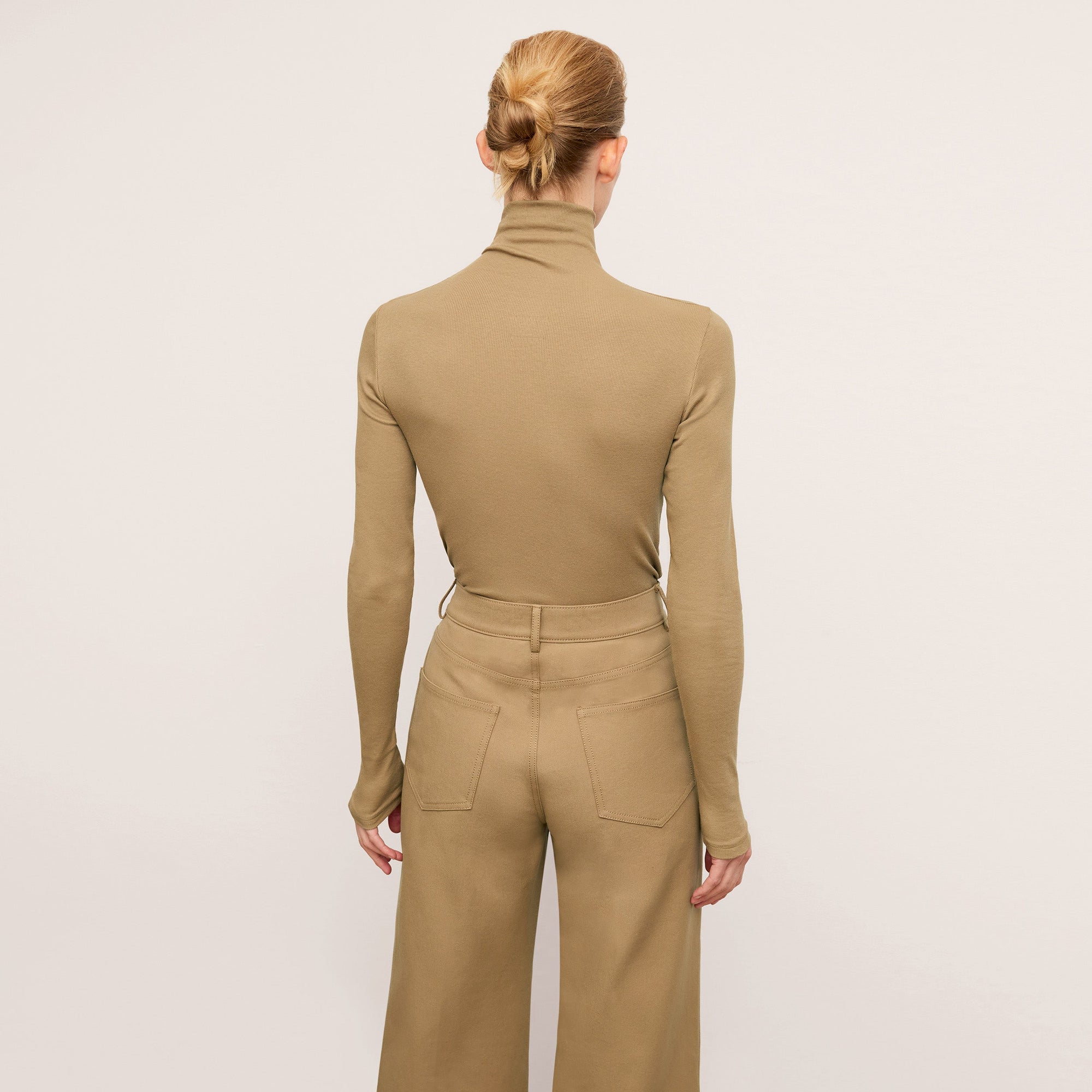 back image of a woman wearing the axam in saddle | Exclude