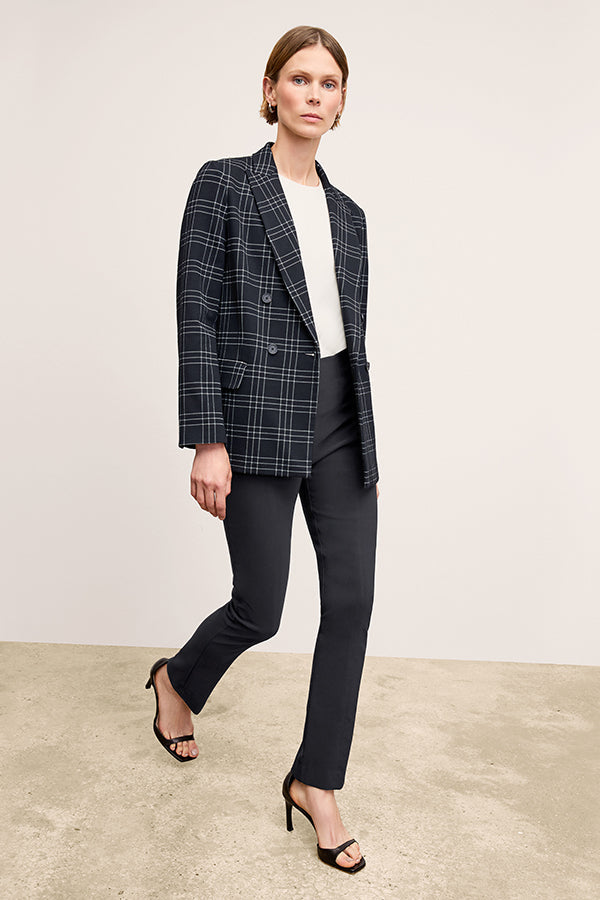 Front image of a woman standing wearing the Foster Pant—Everstretch in Black | Exclude