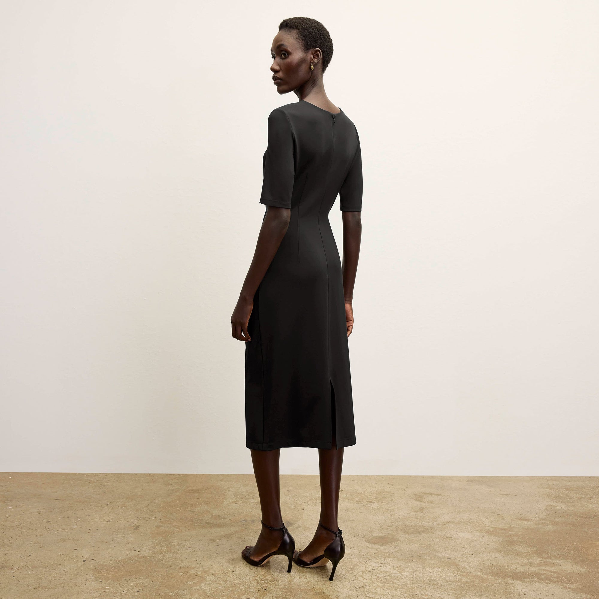 back image of a woman wearing the ciela dress in black 