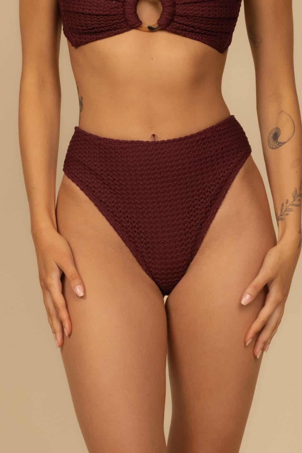 Maroon crochet bikini bottom with textured fabric and high-rise waistband on model.