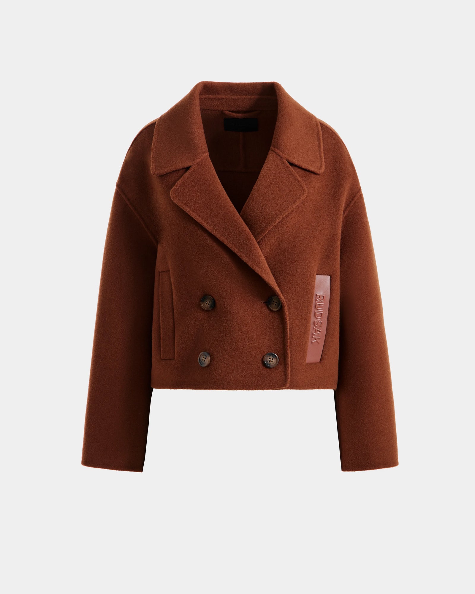 The Rudsak MARTINEZ - 8125580 Rust is a cropped, double-breasted women’s brown wool short coat with wide lapels, button closures, and a pink fabric tag on the left side, shown against a plain white background.