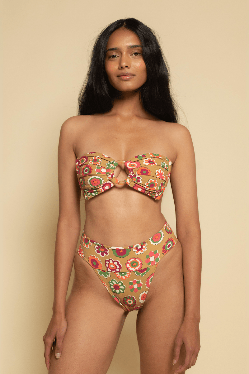 Bandeau bikini top with multicolored floral print on tan background and center tie detail.