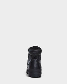 The Rudsak ARTUR - M223501 Black men's ankle boots, crafted from weather-treated leather with a side zipper, pull tab, and RUDSAK embossed heel, are shown from the back against a white background.