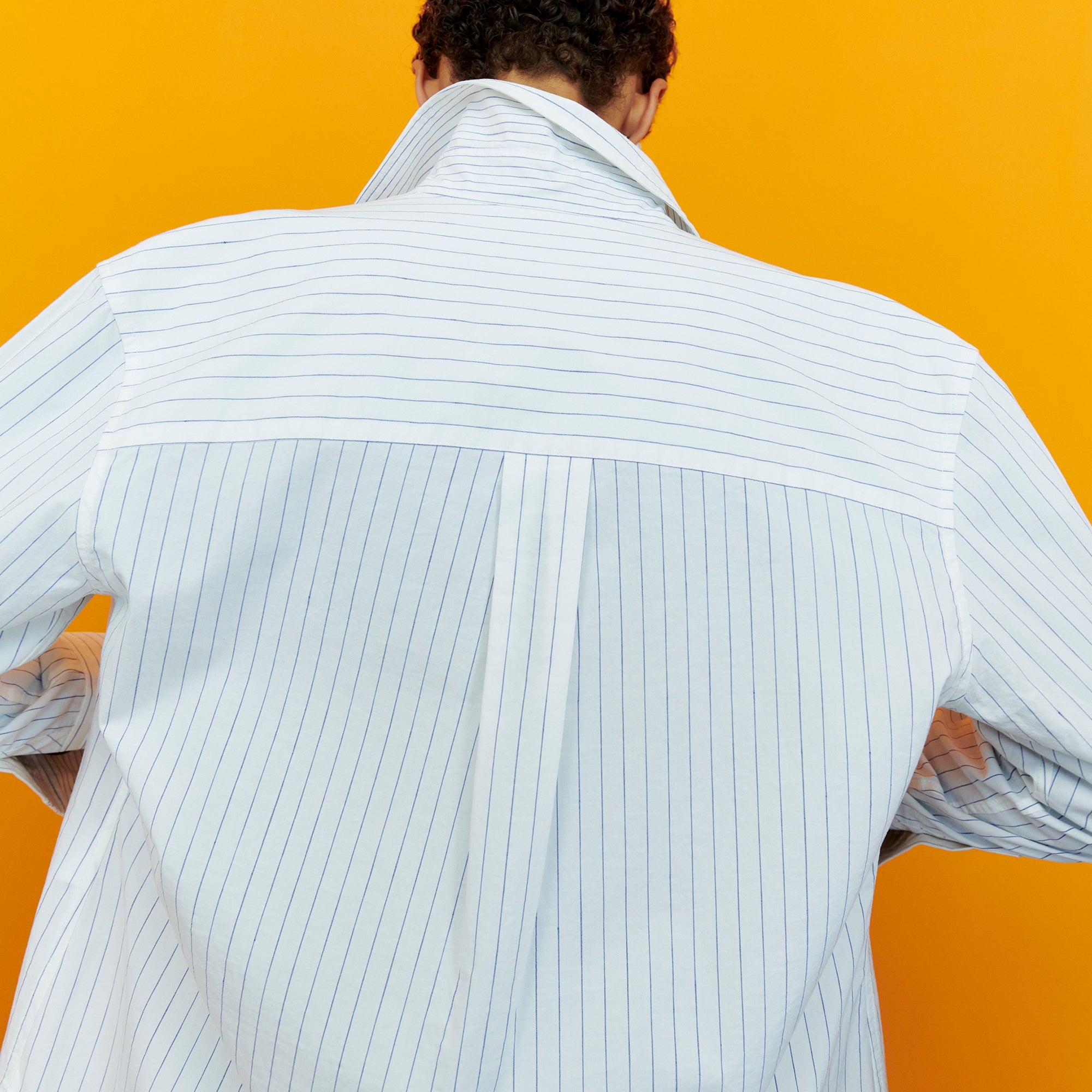Back image of a woman wearing the Mila Button Down - Poplin Stripe in Blue / Ivory | Exclude