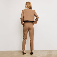 back image of a woman standing wearing the Neale jacket in camel