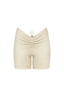 Oat-colored textured shorts with ruched detailing at center back and drawstring waistband.