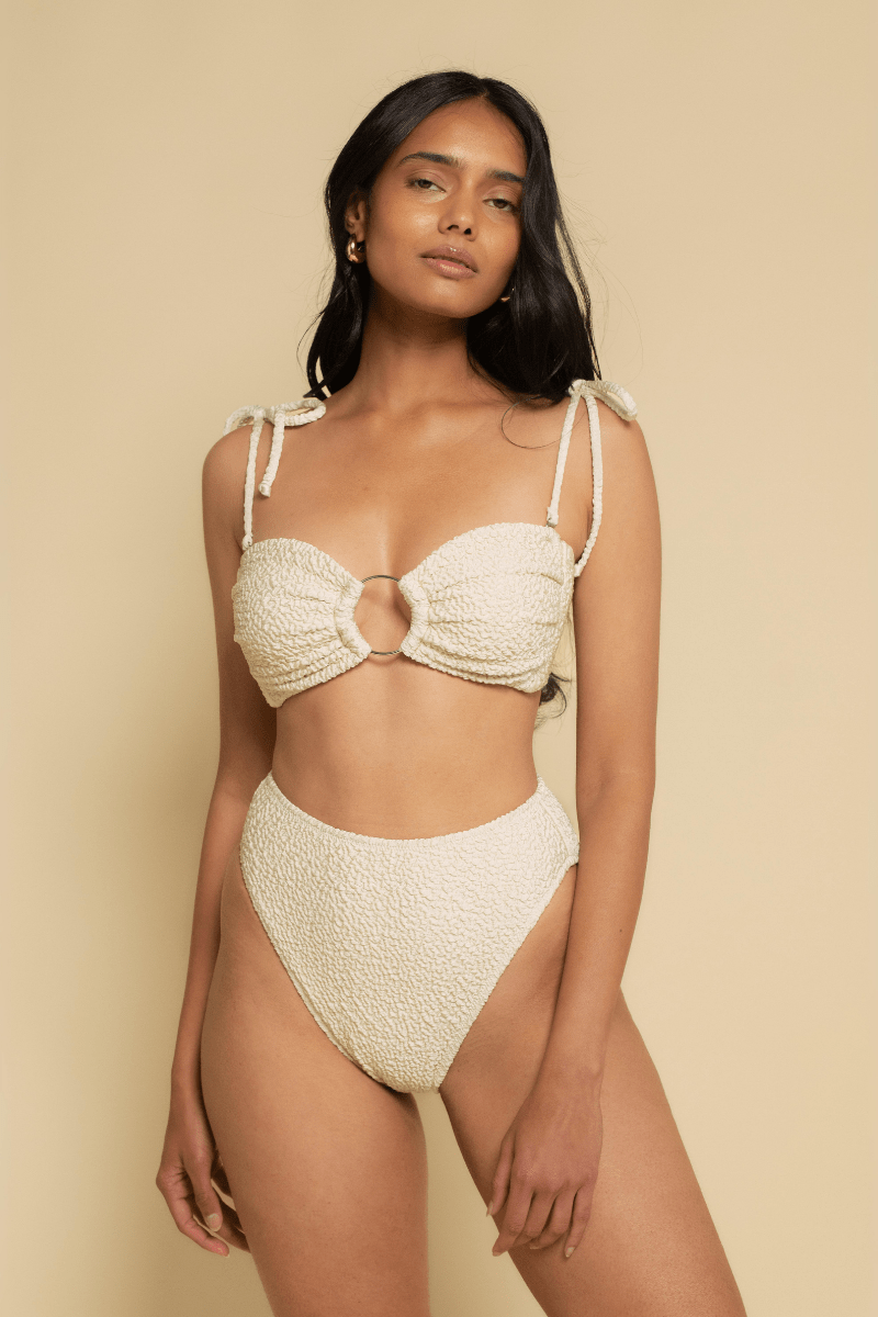 Oat-colored textured bikini bottom with high-waisted cut and textured fabric detail.