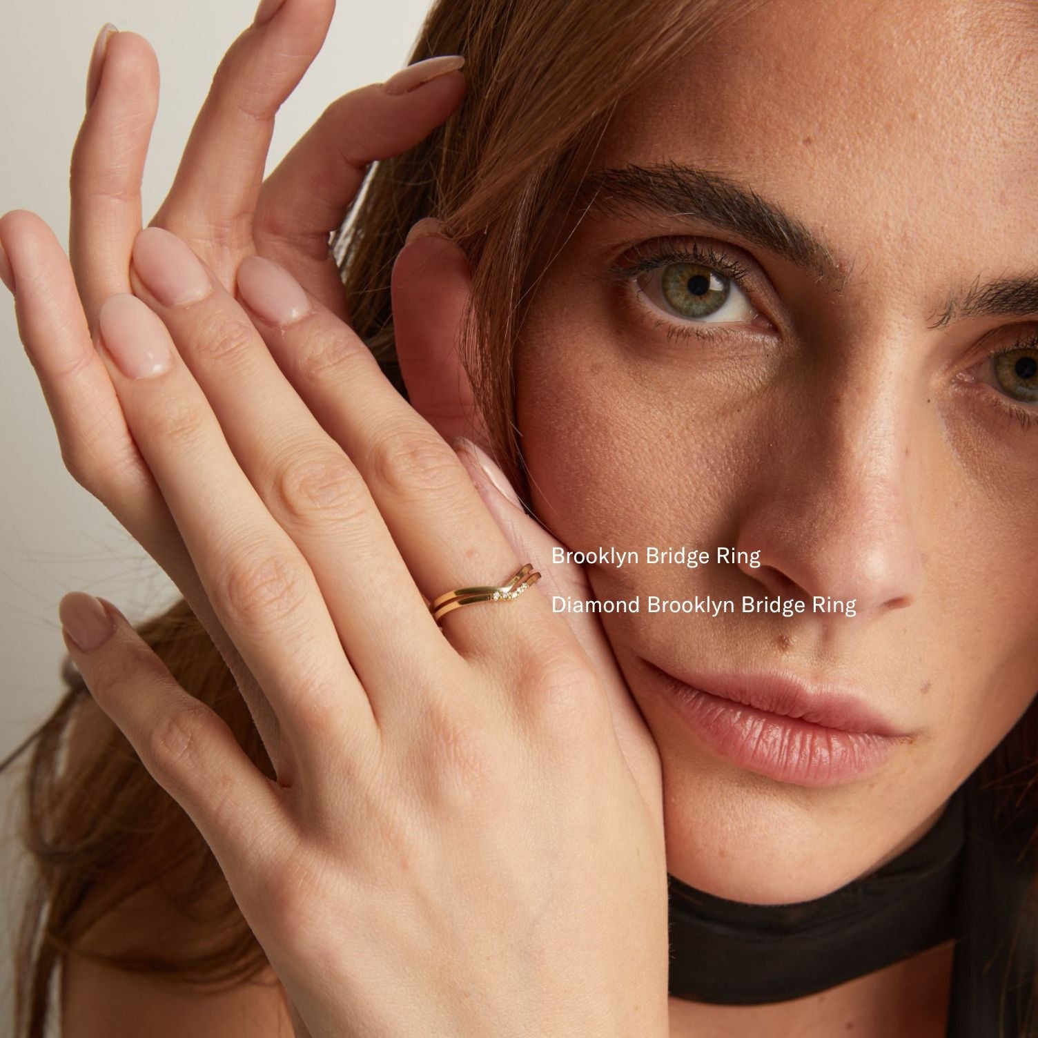 Model. A close-up lifestyle shot of a woman wearing 2 delicate gold band rings.