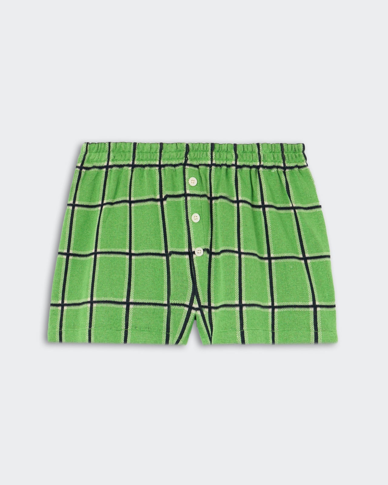 Picnic Plaid Short - Match Point Combo, green knit shorts featuring a bold black and white plaid design, elastic waistband, and front button fly, displayed flat on a light background.