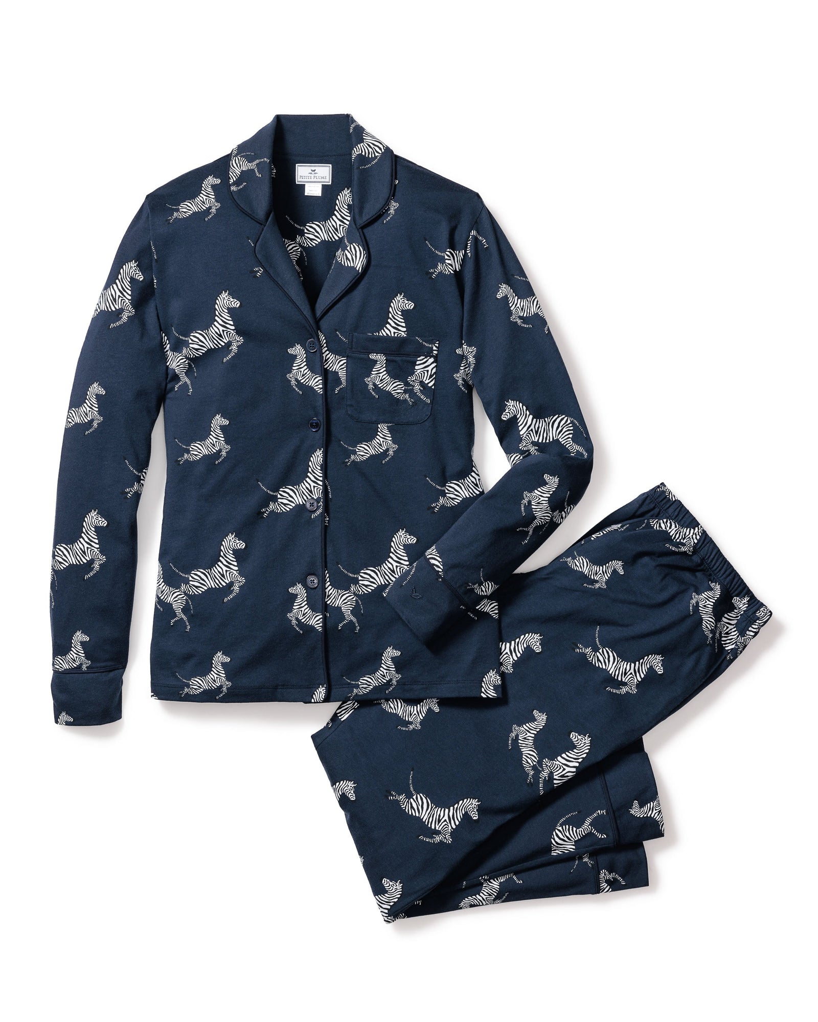 Indulge in luxury sleepwear with Petite Plumes Womens Pima Pajama Set in Zebre de Nuit, crafted from soft Peruvian Pima cotton. This navy set features a zebra print, including a button-up shirt with a chest pocket and collar, paired with matching trousers for ultimate comfort and style.