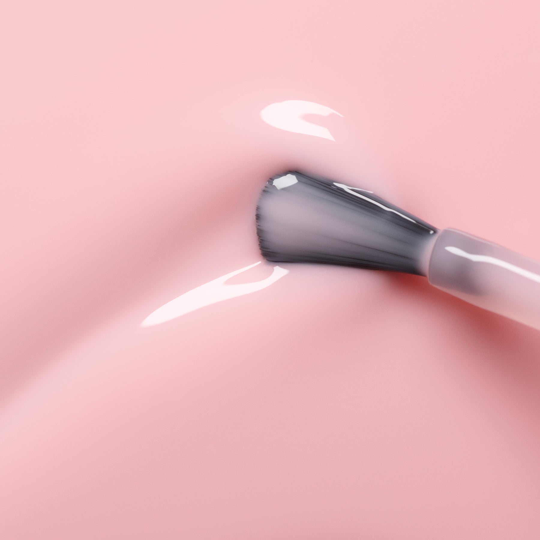 A close-up shows the Manucurist Hortencia nail polish brush applying sheer pink polish on a smooth surface, revealing a soft reflection and shine.