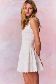 Mini dress featuring scallop detail through the stitch and edge. With a little bit of stretch, thereâ€™s cinching at the waist before falling to a full skirt with a scallop trim.