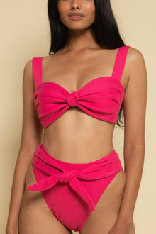 Hot pink bikini top with knotted bow detail and thick shoulder straps on model.