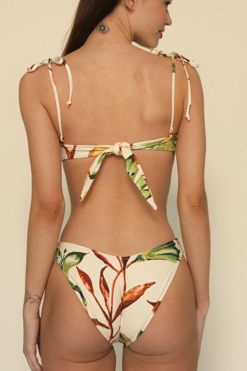 Bikini bottom with cream background and multicolored leaf print, featuring zig-zag stitching and higher leg coverage.