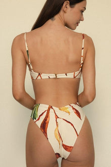 Bikini top with floral leaf print in red, yellow, and green on cream background, adjustable straps.