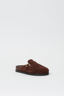 Brown suede slipper with metal buckle detail and black rubber sole, shown in three-quarter view.