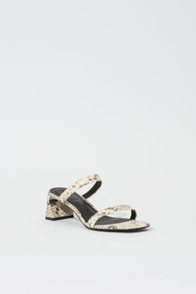 Beige and black snake leather slide sandal with block heel and black sole.