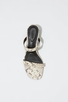 Cream and black snake-textured block heel sandal with strappy upper and black insole, viewed from above.