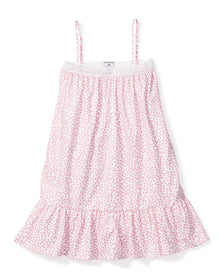 The Girls Twill Lily Nightgown in Sweethearts by Petite Plume is a luxurious sleeveless, knee-length sleepwear piece. It features thin straps, a pink heart pattern on a white background, and is crafted from yarn-dyed cotton with a textured upper section and ruffled bottom hem.