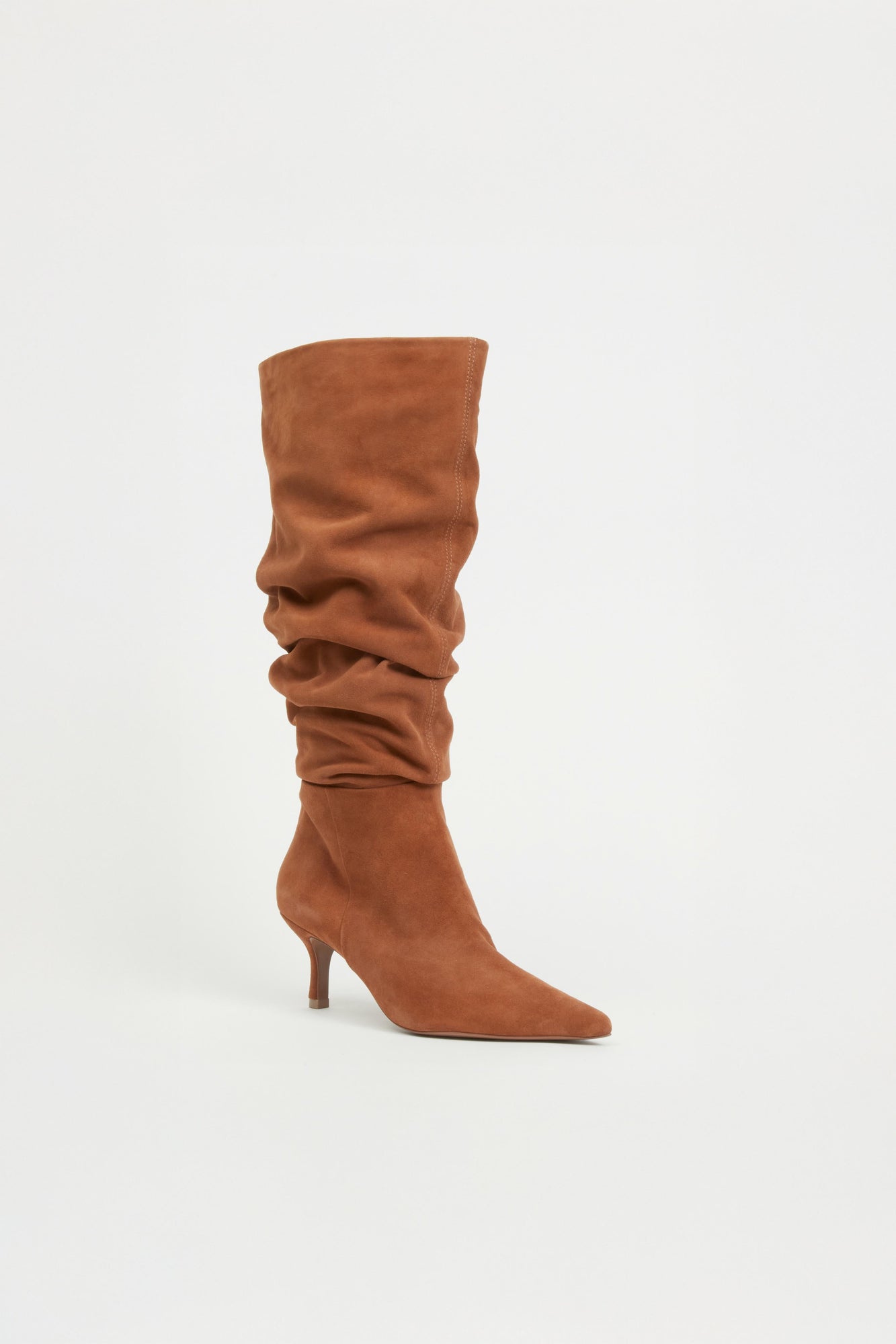Tan suede knee-high boot with gathered slouch detailing and thin heel.