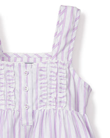 Close-up of Petite Plumes Girls Twill Charlotte Nightgown in Lavender French Ticking, crafted from yarn-dyed cotton with vertical lavender and white stripes. It features a ruched bodice with decorative buttons and soft-textured shoulder straps for a refined look.