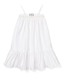 The Girls Twill Lily Nightgown in White by Petite Plume is sleeveless with thin straps, a smocked bodice, and a ruffled hem. Made from yarn-dyed cotton, its light and flowing, perfect for warm weather.