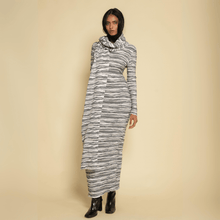 Cream and gray striped knit scarf with textured slub knit worn draped around neck and shoulders.
