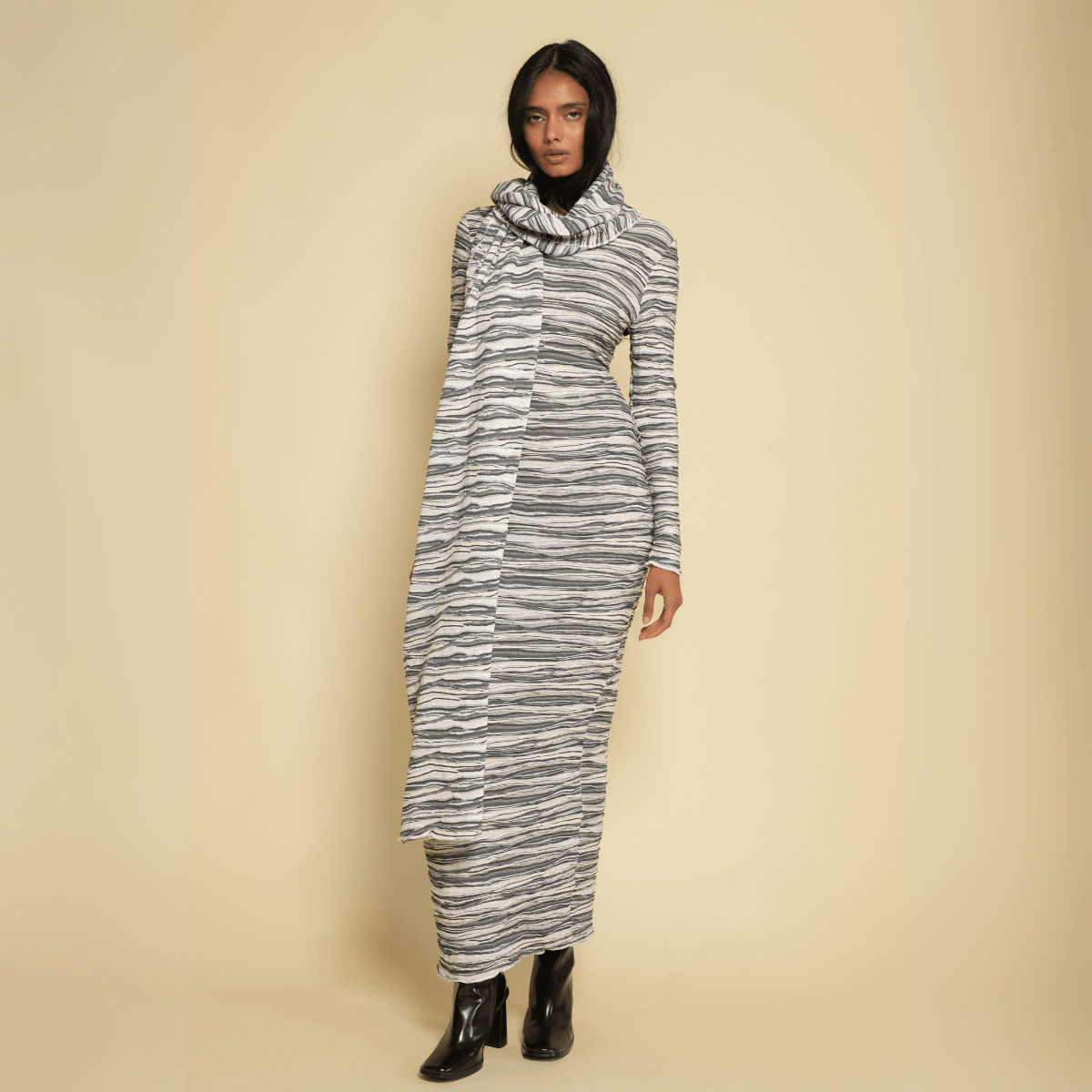 Cream and gray striped knit scarf with textured slub knit worn draped around neck and shoulders.