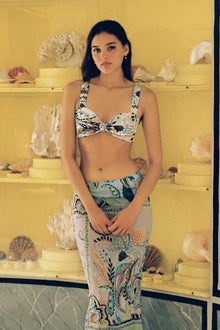 Floral print bikini top with twisted center detail and adjustable straps in cream, navy, and teal tones.
