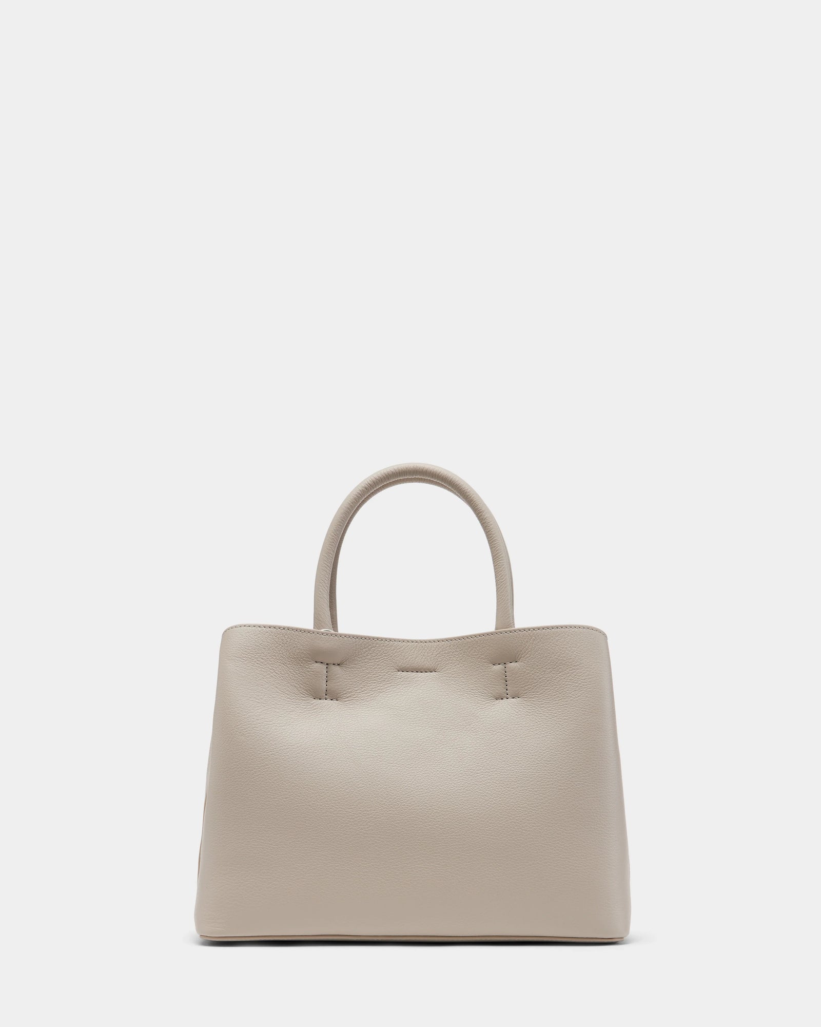 The Rudsak CATIRA S - 8325006 Vanilla is a beige womens pebble leather tote with two rounded handles, a removable shoulder strap, and a minimalist design—no visible logos or embellishments—shown against a plain white background.