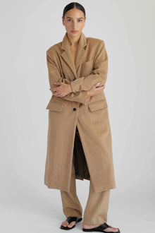 Woman wearing a beige trench coat on a white background